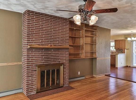 Gas fireplace with exposed brick chimney and built-in wood bookcases are wonderful features of the living room