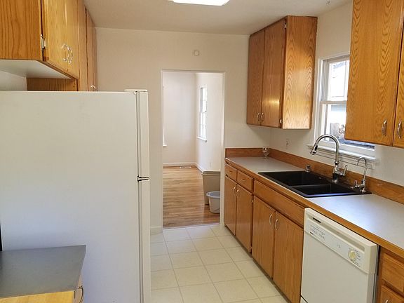 Kitchen with marble sink, electric range, refrigerator, dishwasher, disposal, water filter.