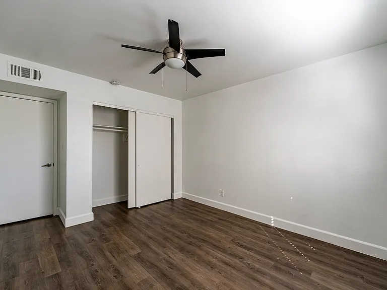 2nd bedroom with neutral paint, bright natural light, and ceiling fans for those hot summer days.