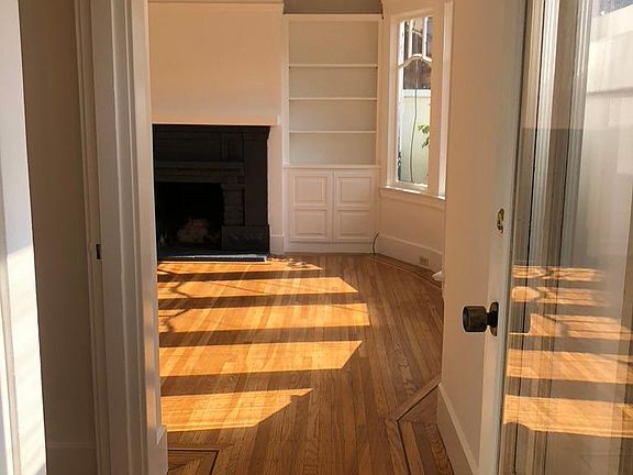 Entrance to the house looking into the sunny living room with its fireplace and built-in bookshelves.