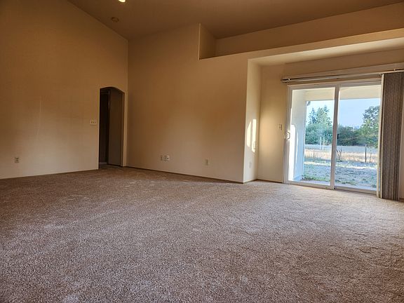 Great room looking towards sliding door to patio & back yard; hallway to bedrooms