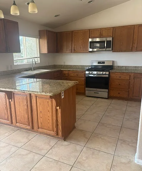 The kitchen has granite and a beautiful view of the outside.