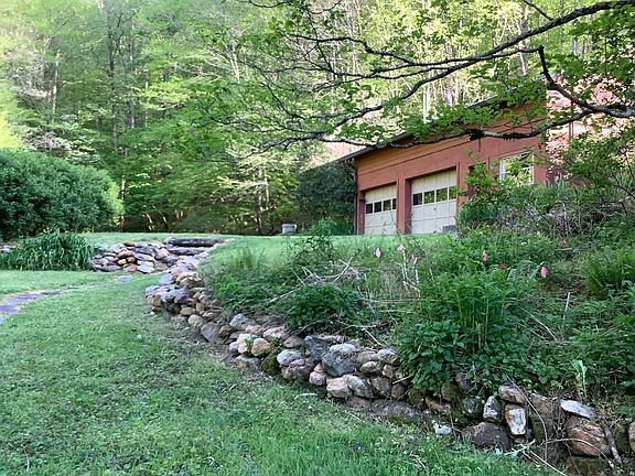 Large garage in back. Fire pit by a small pond to the left. National Forest up the hill.
