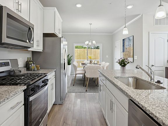 Island Kitchen with LVP floors and stone cabinets in a DRB Homes Alden Plan at the WestRidge at West