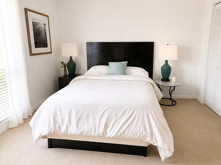 Well-appointed bedroom with a queen bed, matching nightstands, soft carpet, and a closet for everyday storage.