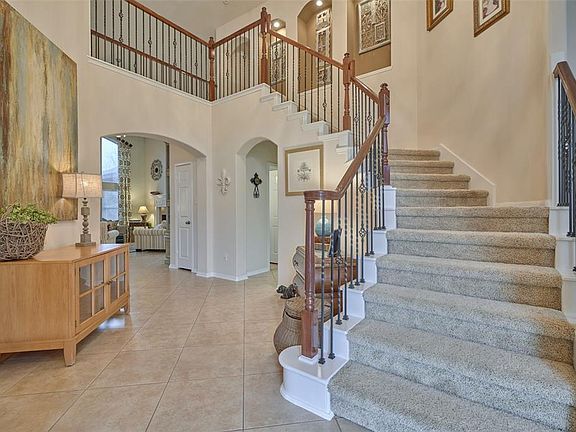 This is what greets you as you enter through the front door. Sweeping stairs to the second level with office/living room on right and formal dining room on the left. The Family Room is beyond the arch. Tiled floor (laid on diagonal) throughout the lo