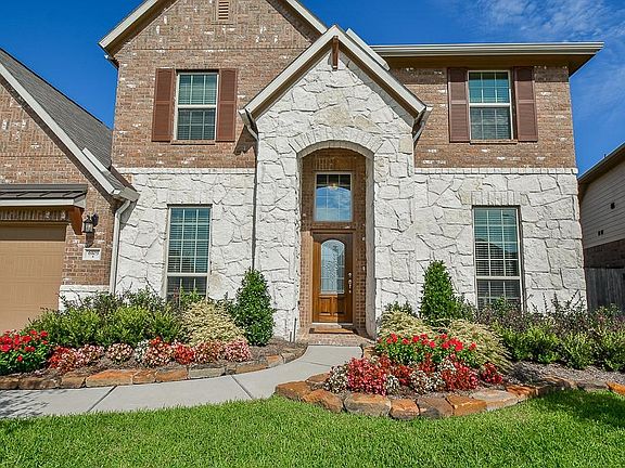 Great curb appeal with upgraded stone elevation, colorful landscape and desirable location in Long Meadow Farms.
