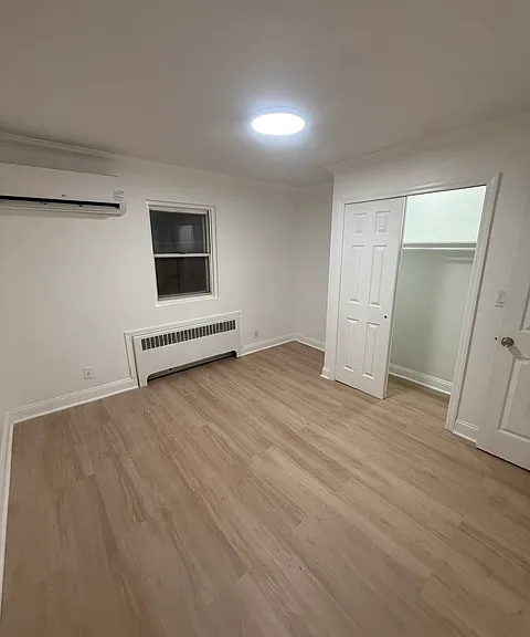 Bedroom with mini split, laminate floors & closet