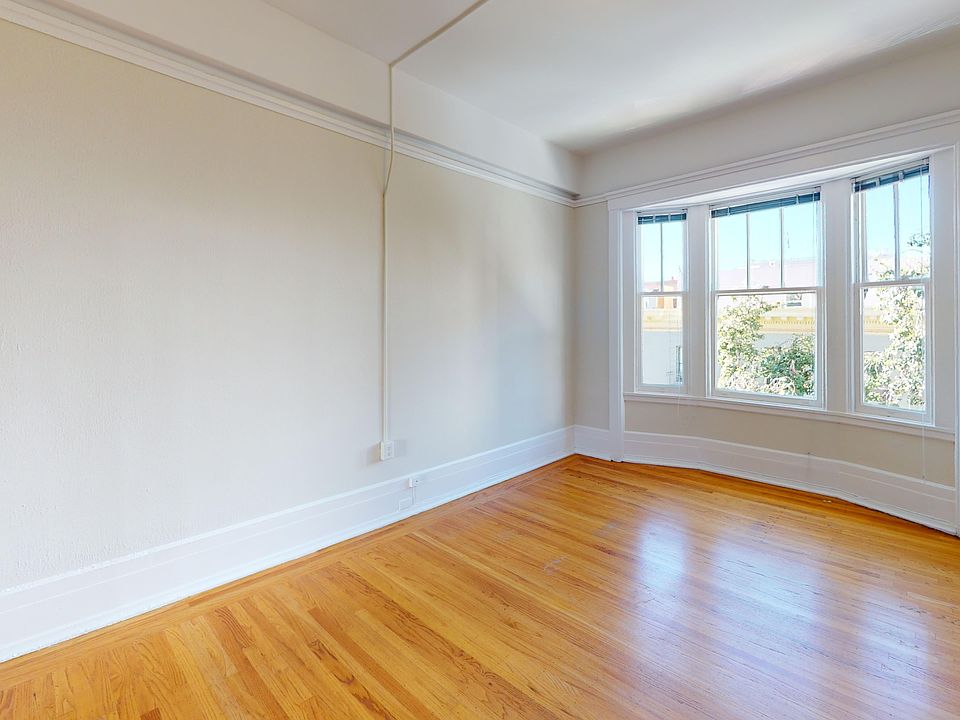 Bright room with wooden floor, large window, and ample natural light