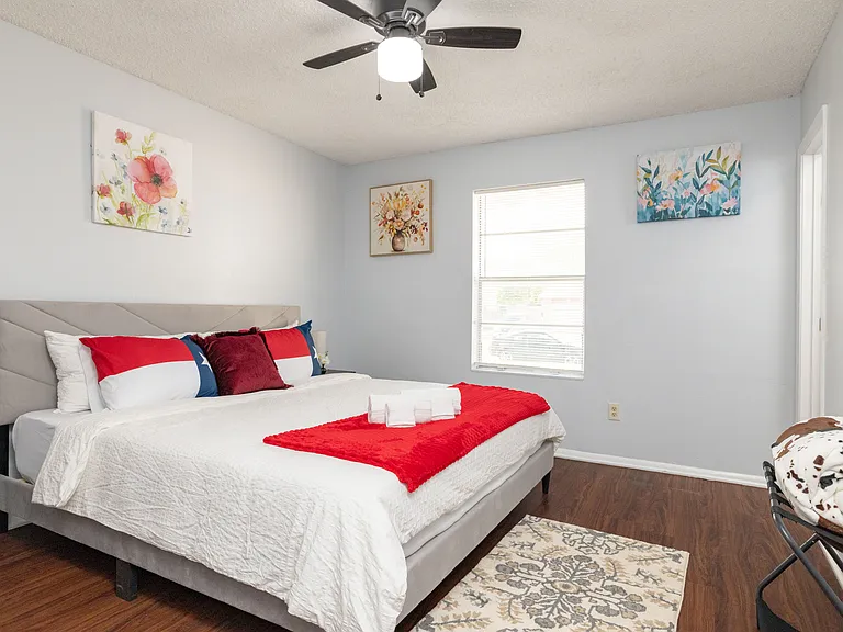 Bright and airy, Bedroom 4 includes a king bed, ceiling fan, and lovely floral wall decor.