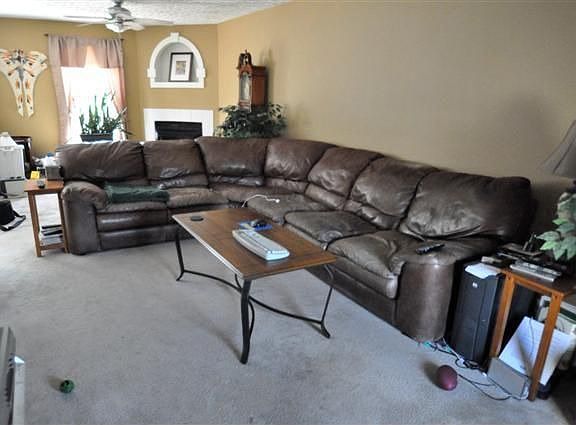 Large family room has neutral colored carpeting. 