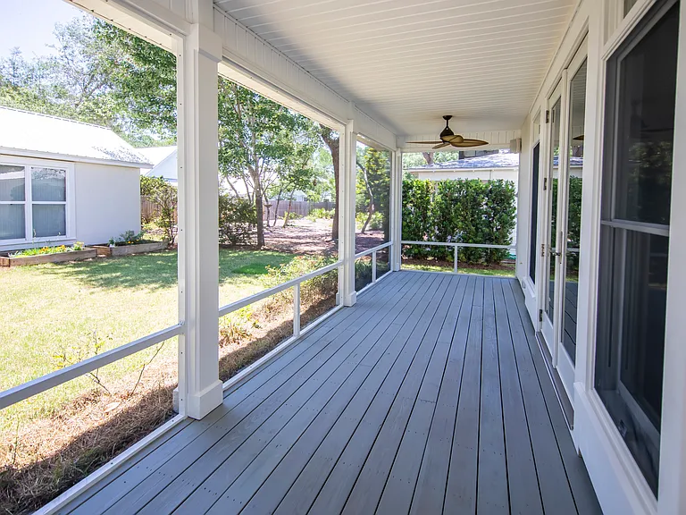 Large screened in porch with landscaped yard.