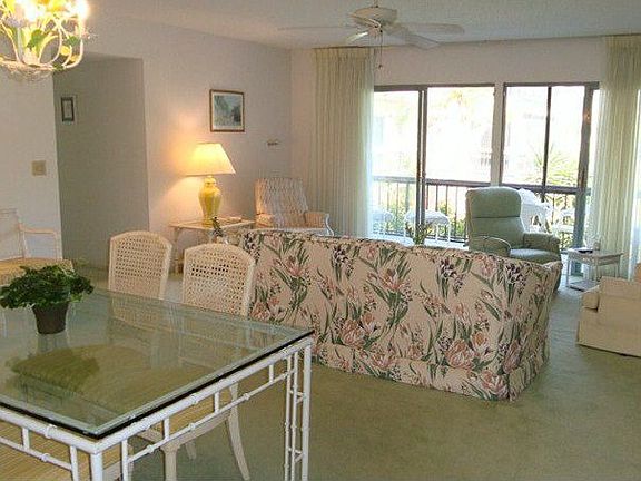 Formal living room with access to screened patio overlooking golf course