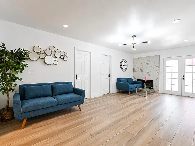 Spacious living area with wide-plank flooring, recessed lighting, and seating space plus French doors for easy outdoor access