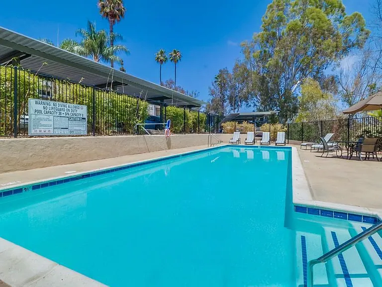 Sparkling swimming pool, hot tub and lounge chairs.