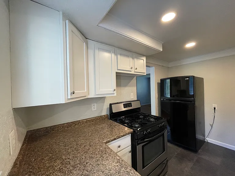 second view of kitchen, fridge included, recessed lighting