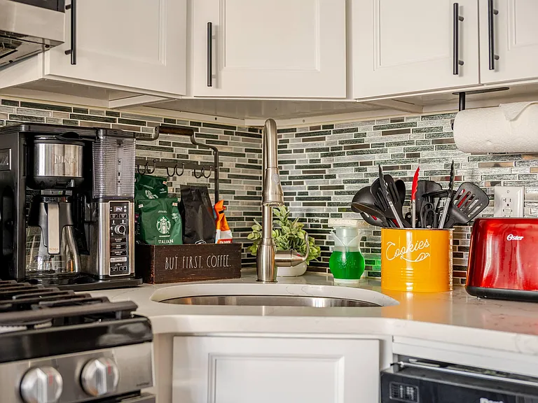 Functional kitchen workspace with ample cabinetry, tile backsplash, and an undermount sink with gooseneck faucet.