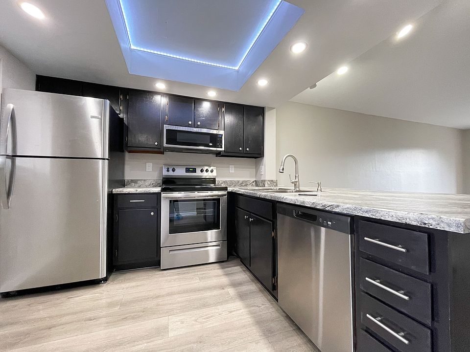 Chef-inspired kitchen with stainless steel appliances and a color-changing ceiling light.