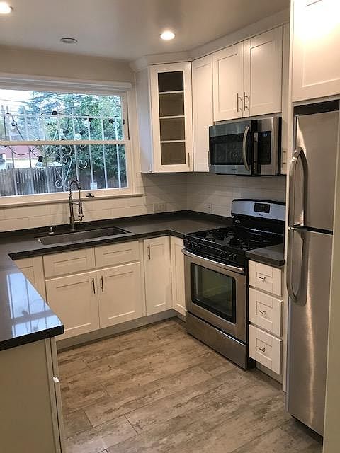 New kitchen, stainless appliances, large window above the sink, looking toward the beautiful yard
