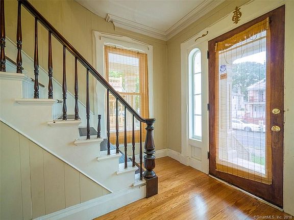 Lovely Staircase with large windows in the foyer.