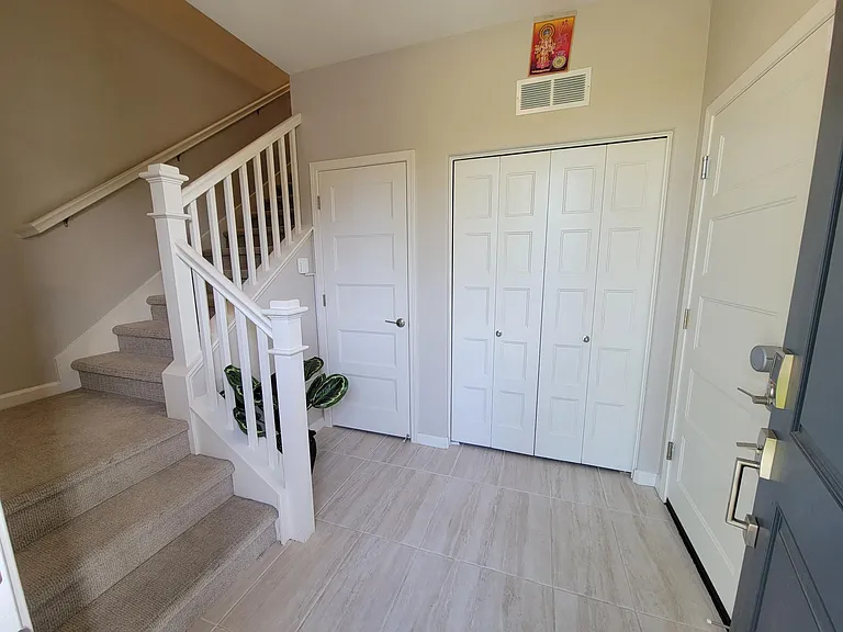 Spacious landing area equipped with shoe closet and washer dryer unit.