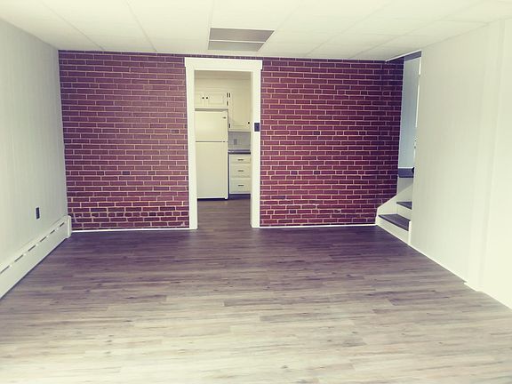 Come down 3 steps into the dining room that features a brick wall