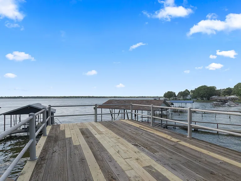 Private boat dock with wood-finish decking and metal railings