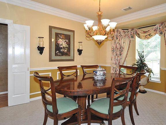 Dining room will accommodate a large table and has beautiful crown moulding, chair rails and a bay w