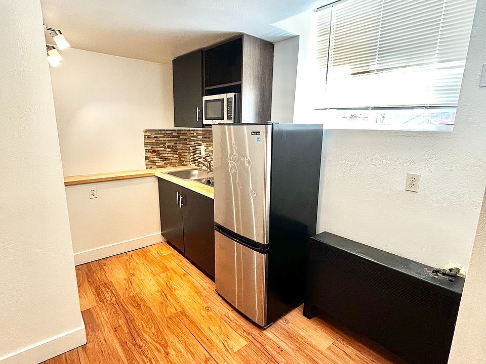 Chic modern kitchen with stylish backsplash, sleek cabinetry, and natural light highlighting the hardwood floors.