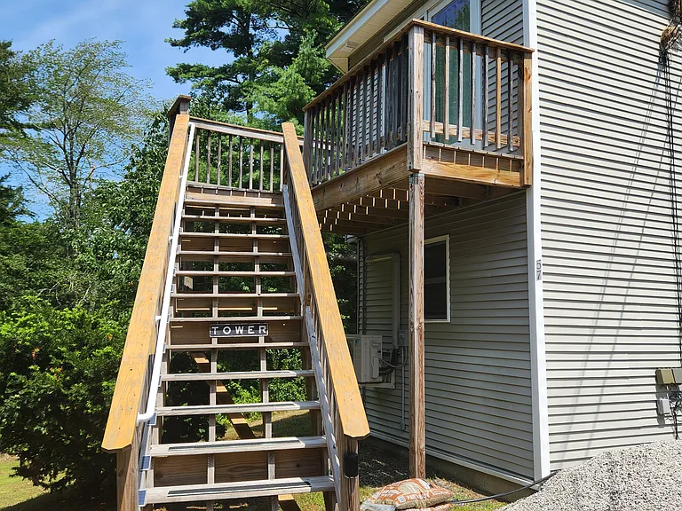 Bedroom 3 with queen bed on second floor, separate entrance, mini-fridge, mircowave, smart TV, fold away table and chairs, shower stall, bathroom sink, toilet, and views of backyard.