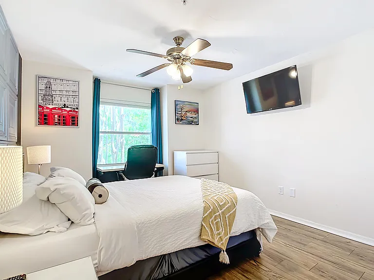 Second bedroom, with queen tempurpedic bed, wall-mounted smart TV and desk.