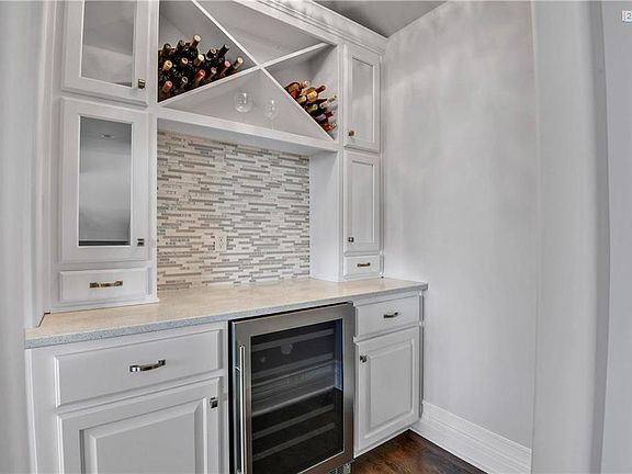 Butlers Pantry features custom tile back splash, wine refrigerator and quartz counters.