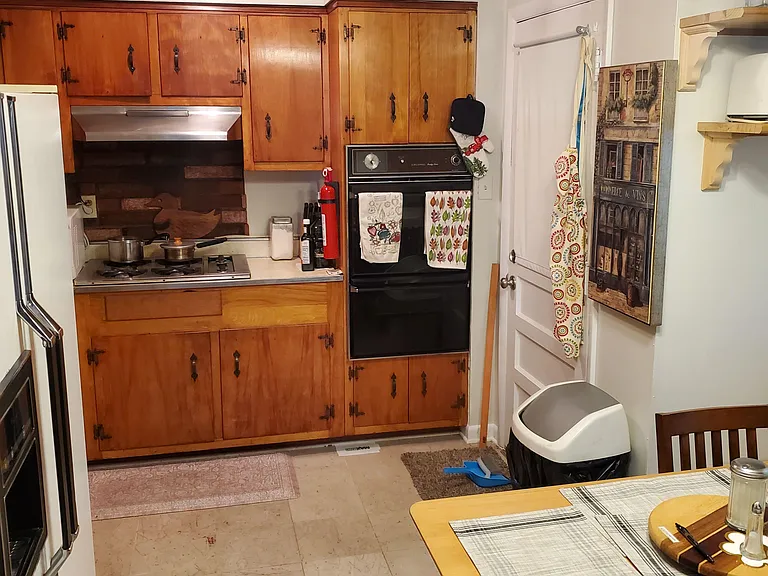 Functional eat-in kitchen with ample wood cabinetry, gas cooktop, and adjacent table space for everyday meals.
