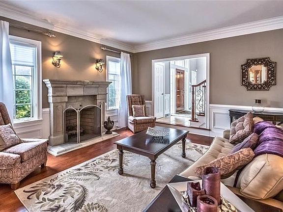 To the right of the foyer is the sunken formal living room with limestone like fireplace, gleaming hardwood floors, all topped w