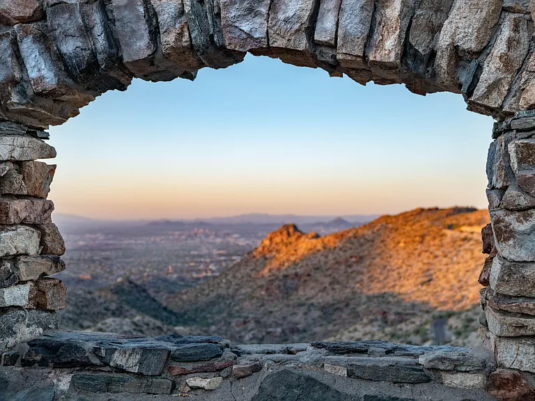 Elevated outdoor lookout framed by rustic stonework, offering sweeping mountain and valley views for relaxing sunsets.