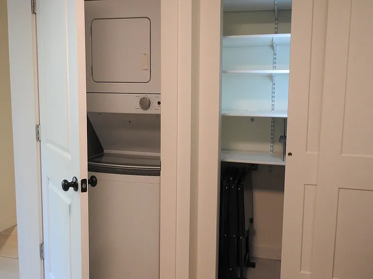 Stacking washer/dryer in unit and lighted pantry for ample storage.