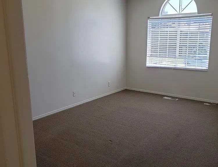 Large master bedroom with large window and two large closets.