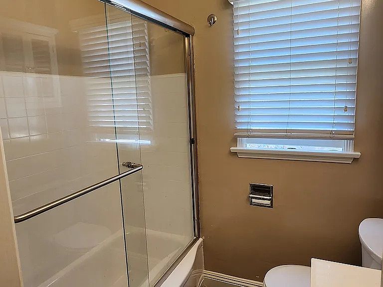 Another View of Bathroom with Sliding Glass Shower Door and Has a Bathtub