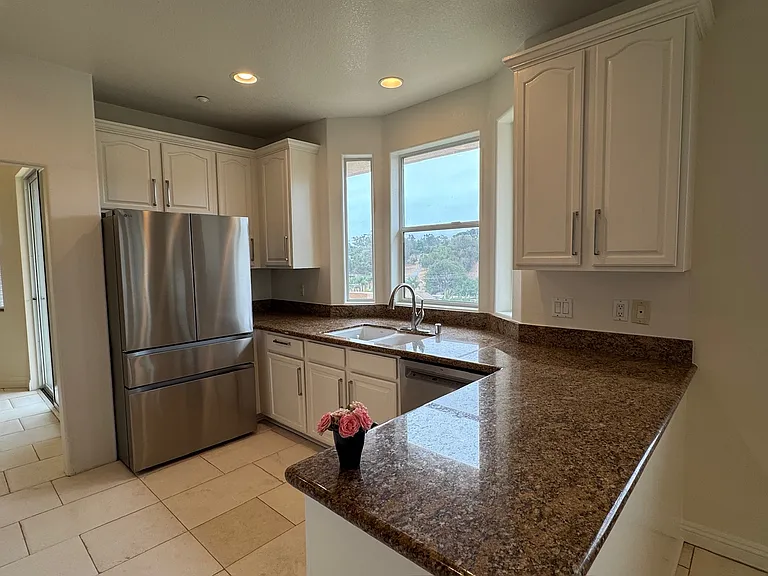 Kitchen leads to the formal dining room and family den. Open concept living spaces.