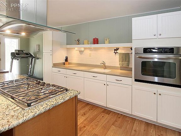 Kitchen includes an island with granite top and 5-burner gas cooktop