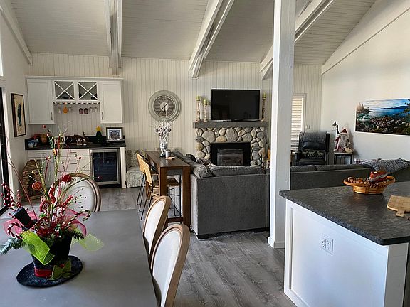 Open concept with sectional sofa, cozy fireplace and dining table for 6