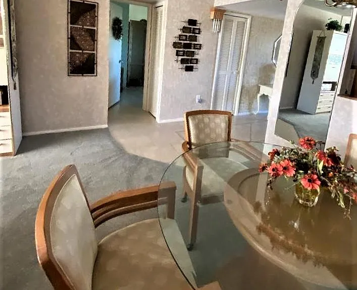 View from dining room through hall to master bedroom. Utility closet bi-fold door is shown in entrance hall.
