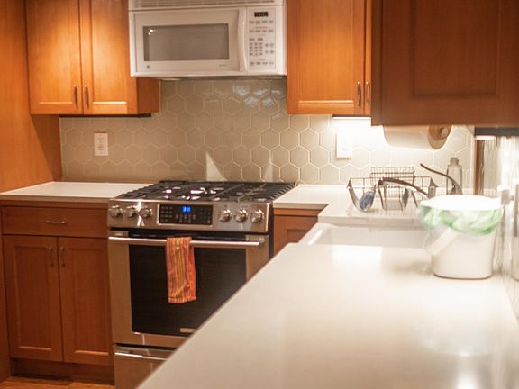 Newly remodeled kitchen with brand new gas range, microwave and dishwasher. Custom reclaimed old growth fir cabinets and custom tile backsplash.
