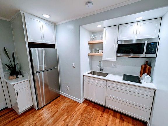 Kitchen with full sized fridge, microwave, 2 burner cooktop
