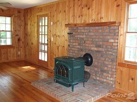 Enjoy Family Time Surrounded by the Pine Tongue & Grove Hardwoods and Cast Iron Wood Burning Stove