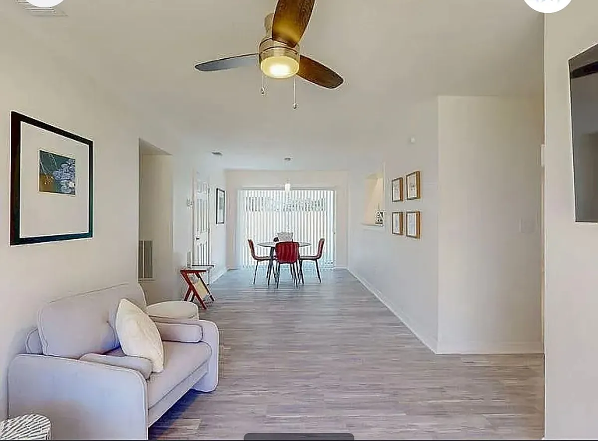 Open-concept living and dining area with hardwood-style floors, ceiling fan, and natural light throughout - 2006 E Hanna Ave #2