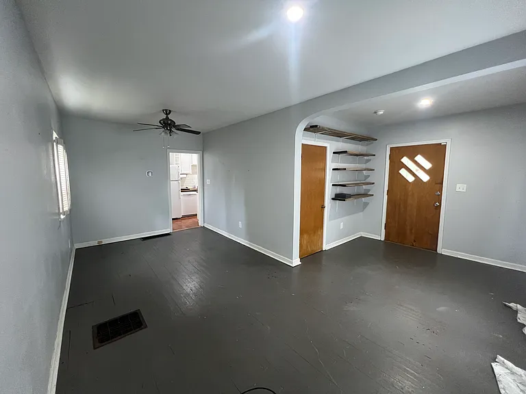 Nice size living room with shelving and closet.