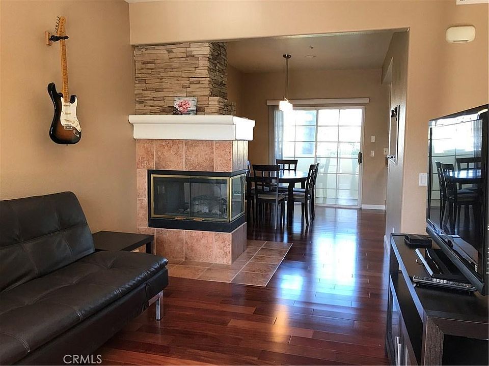Living room and dining room are on the second floor, separated by the fireplace. The two patio doors leading to the balconies are offering great amounts of natural light