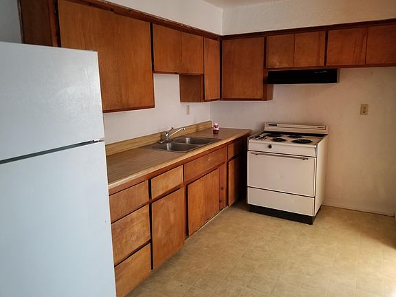 Kitchen with electric stove, refrigerator and lots of cupboard space.