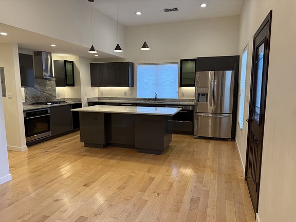 Gourmet kitchen with beautiful granite countertops equipped with stainless steel appliances, featuring a large breakfast island.